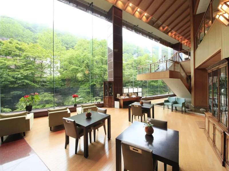 Covered open-air hot spring bath with wooden beams and rocks at a traditional ryokan in Noboribetsu Onsen near Noboribetsu Bear Park, Hokkaido